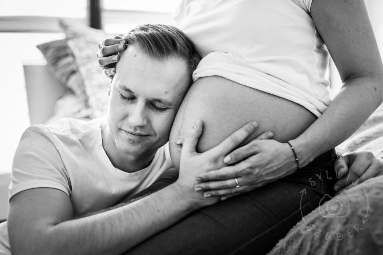 przyszły tata przykłada ucho do ciązowego brzucha