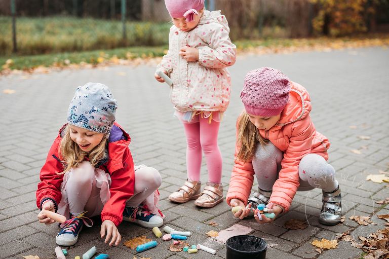 trzy siostry rysują kredą po chodniku