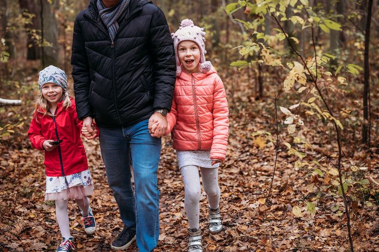 tata idzie za ręce z córkami